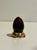 Dark wine-colored crystal egg on a gold stand